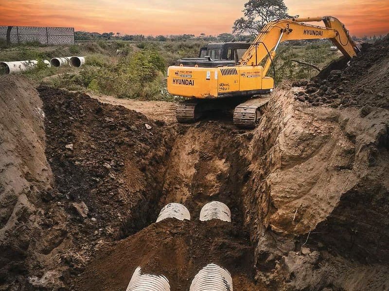 Large corrugated sewer pipe being laid in an open trench